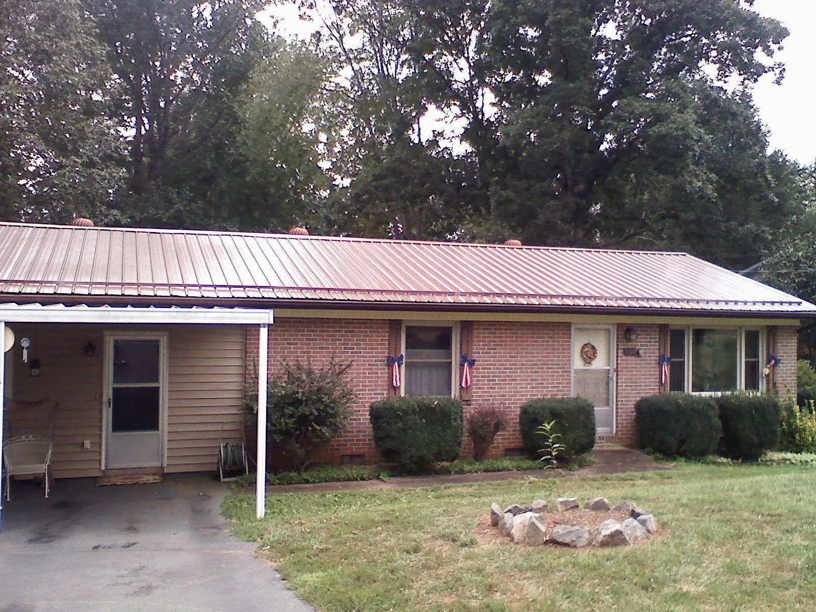 Bronze metal roof and carport on a brick ranch home — Roof Repair work by our crew in Graysville